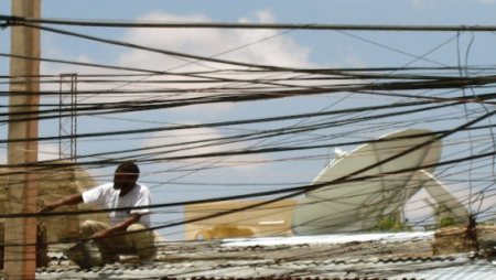 A photo of a man sitting with electricity wires, taken by Dr Stremlau during her fieldwork