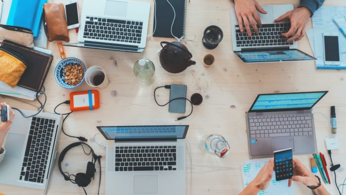 A photo of different laptops on a table for collaborative working