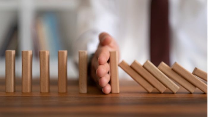 A photo of a hand stopping wooden blocks from falling