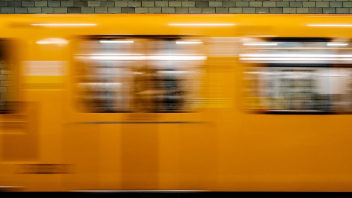 A yellow Berlin train rushes past.