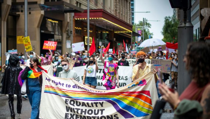 At an LGBTQ march, a banner reads 'Equality Without Exceptions'