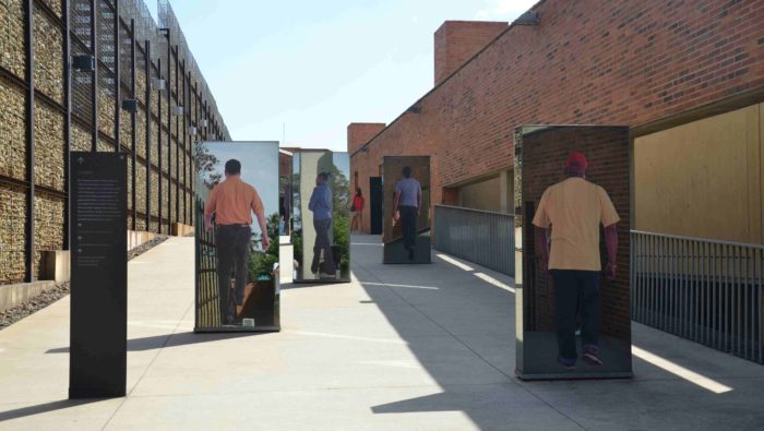 A slope in an outdoor museum with pictures of black persons walking up.