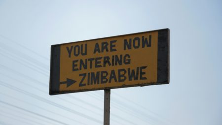 A roadsign reads You Are Now Entering Zimbabwe