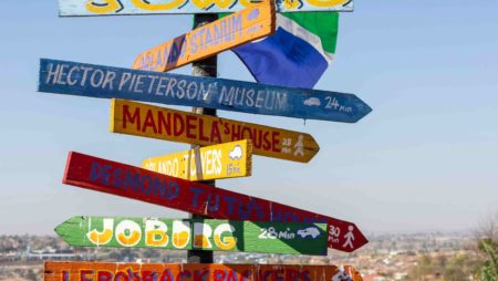 A post with colourful signs pointing to different places and sights. Close to Johannesburg, SA.