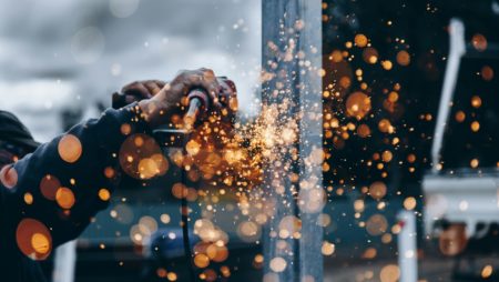 A worker using an angle grinder makes sparks