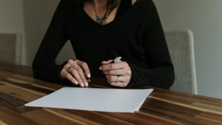 Women sitting at a table with a pen and a white piece of paper