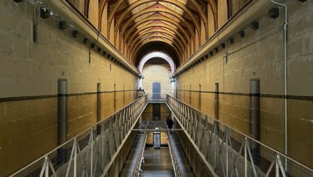 A long hallway with a walkway in a prison