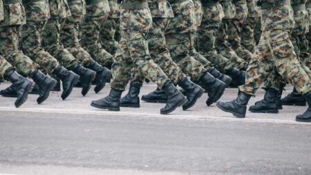 Soldiers dressed in army camouflage march in formation
