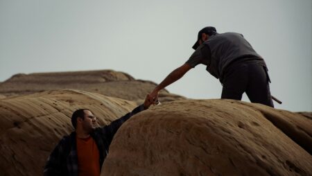 A person reaching someone else's hand while working on a field