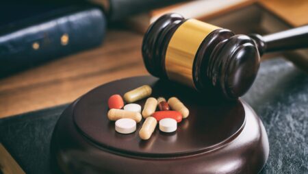 Court gavel placed near some pills.