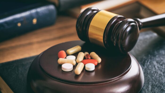Court gavel placed near some pills.